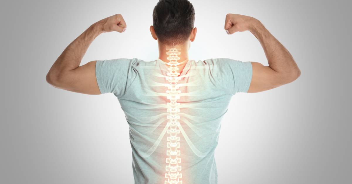 Man viewed from behind flexes both arms with an illuminated illustration of the spine and rib cage over his back.